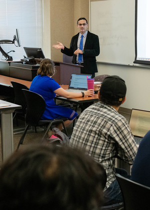 Professor Serkan Karadas teaches a class with seven students visible in the photo.