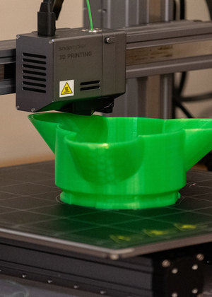 3D printer printing a three petal dish at the University of Illinois Springfield Orion Lab 