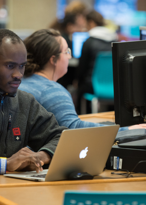 Man sitting at a desk looking at a laptop