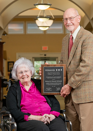 Hannah and Richard McDaniel posing for a photo with the award.