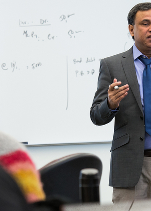 UIS professor Mohammed Mohi Uddin teaching a class using hand gestures in a classroom. 