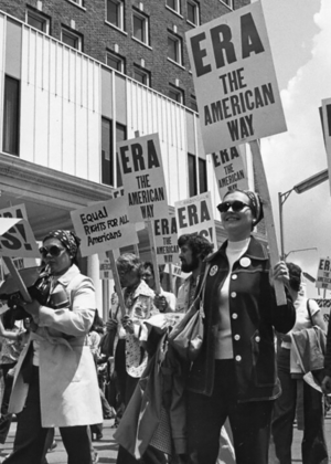 Women holding signs that say "ERA" march through the streets of Springfield in 1982 as part of an Equal Rights Amendment rally.