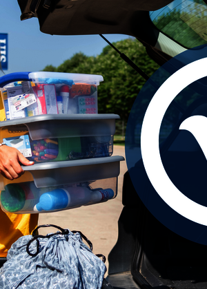 A move-in volunteer is loading boxes into a cart.