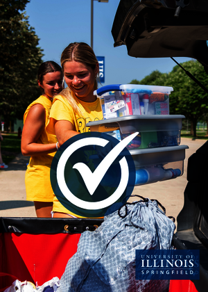 A move-in volunteer is loading boxes into a cart.