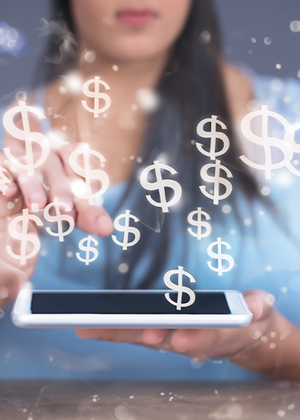 A person using a tablet with dollar signs appearing