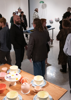 A group of people gathered to view art in the gallery.
