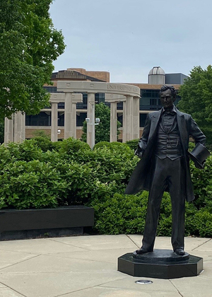 the lincoln statue on campus with a background of the colonnade