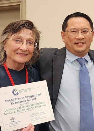 Lenore Killam and Brian Chen hold a Public Health Program of Excellence Award from the Illinois Public Health Association.