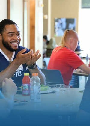 A group of people are sitting at a table, engaged in conversation at the University of Illinois Springfield.