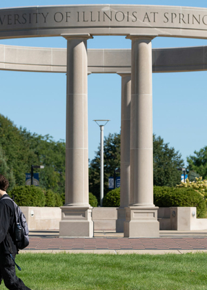 two UIS students walking in front of the colonnade