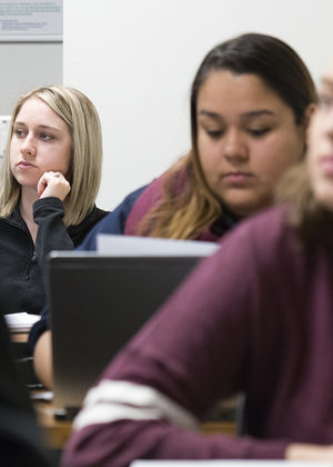 Students in a legal studies class at UIS listen to a lecture and take notes on their laptops.