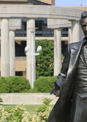 Statue of Abraham Lincoln with the UIS colonnade in the background.