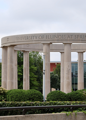 Campus Colonnade; nearby, a "UIS" banner and building in background.