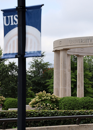 University Colonnade and a UIS banner, overcast sky.