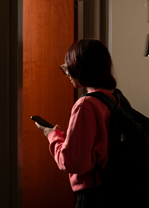 Person with a backpack entering a financial assistance office