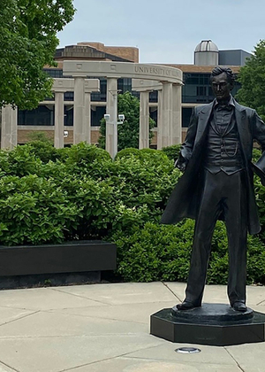 Abraham Lincoln statue on campus is in the foreground and the colonnade is in the background