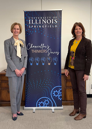 Two women standing beside a University of Illinois Springfield banner.