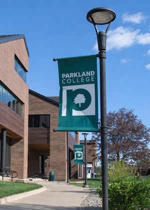 Modern building with a wooden facade under a bright blue sky and scattered clouds.