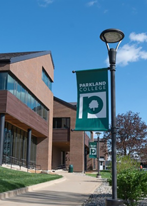 Parkland College banner on a lamppost, clear blue sky.