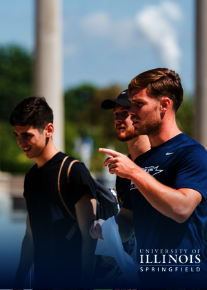 Three men walking outdoors, one pointing ahead, with tall columns in the background.