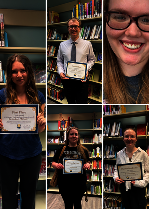 Five people in a library holding certificates, smiling.