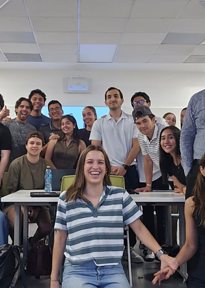 Group of people smiling in a classroom setting.