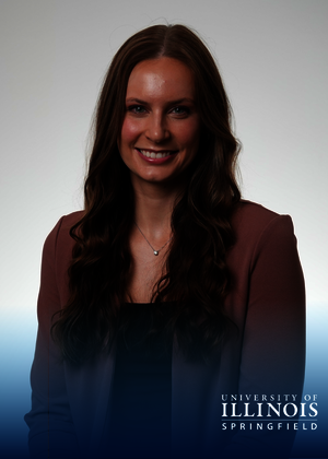 Smiling woman in a blazer. Blue, hombre box at the bottom with the logo University of Illinois Springfield.