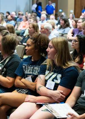 Audience seated attentively in a conference room.