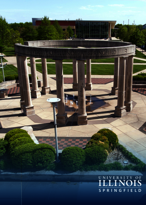 Circular stone structure on a campus with surrounding greenery.