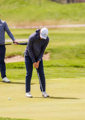 Julien Babineau golfing in gray and blue UIS gear
