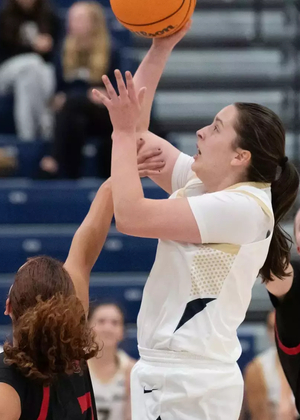 Brooke Spychalski playing basketball in white UIS uniform