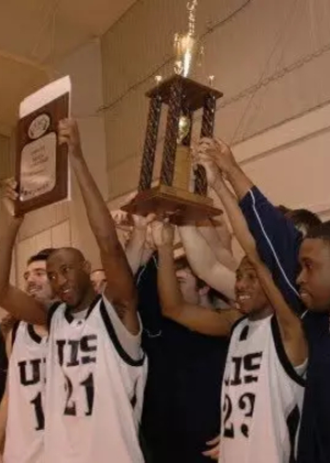 UIS Basketball Players Hoisting Trophy