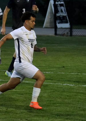Leo Sanches playing soccer in white UIS uniform