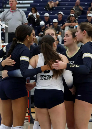 UIS Volleyball team in a huddle on the court