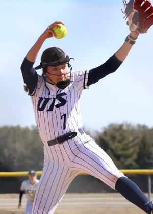 Rosie Bartletti pitching in white uniform