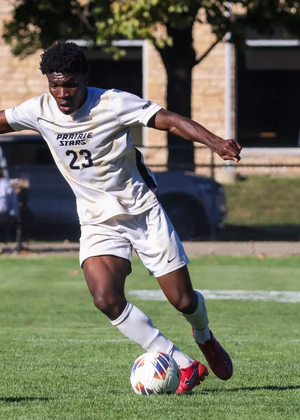 Promis Ahupa playing soccer in white UIS uniform