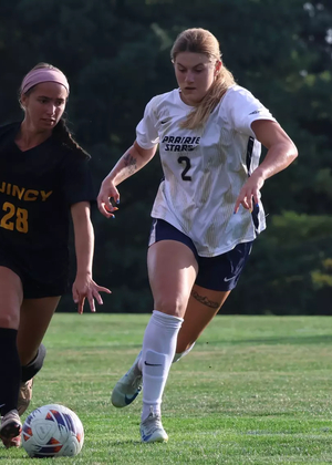 Kalli Drexler playing soccer in white UIS uniform