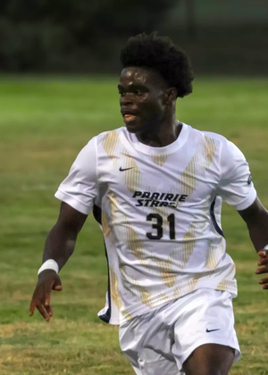 Brandon Djenebia playing soccer in white and gold UIS uniform