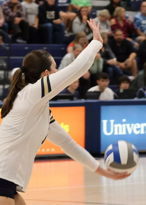 Makenna Cox serving in volleyball