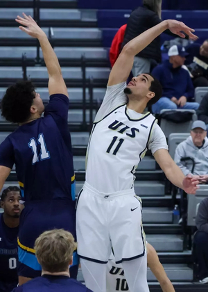 Donaven Younger jumping during tip-off at home UIS basketball game