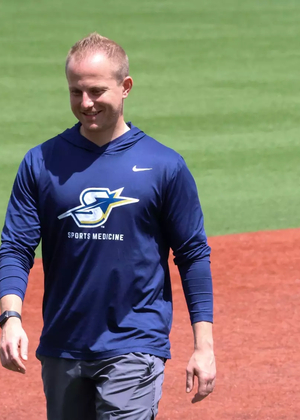 UIS Athletic Trainer Ryan Margold walking across baseball field