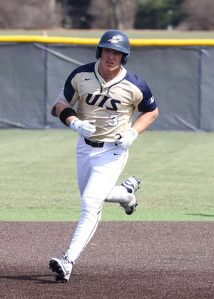 Kaden Griffitts running the bases in gold UIS uniform