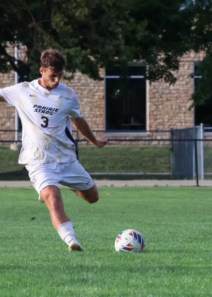 Adam Knaze playing soccer at UIS in white uniform