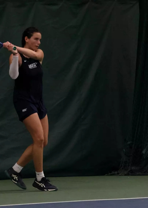 Ema Norma Bordean playing tennis in blue UIS uniform