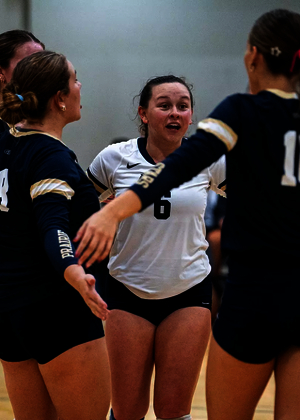 UIS Volleyball team huddle on the court