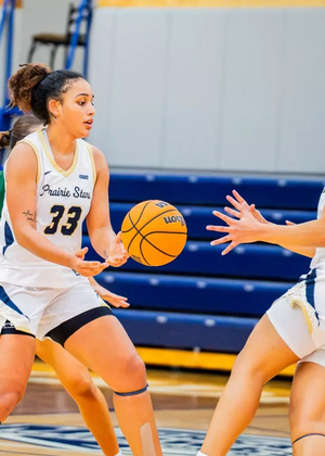 Allysia McDaniel and Kayla Rice playing basketball in white UIS uniforms