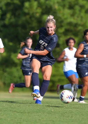 Rachel Riney kicking soccer ball during a game