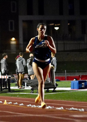 Mackenzie Billard running outdoor track in the evening in blue UIS uniform