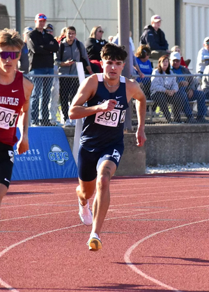 River Derby running outdoor track in blue UIS uniform