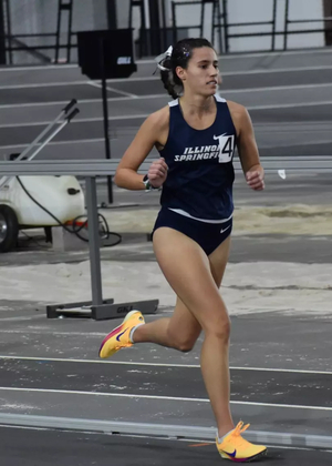 Mackenzie Ballard running indoor track in blue UIS uniform